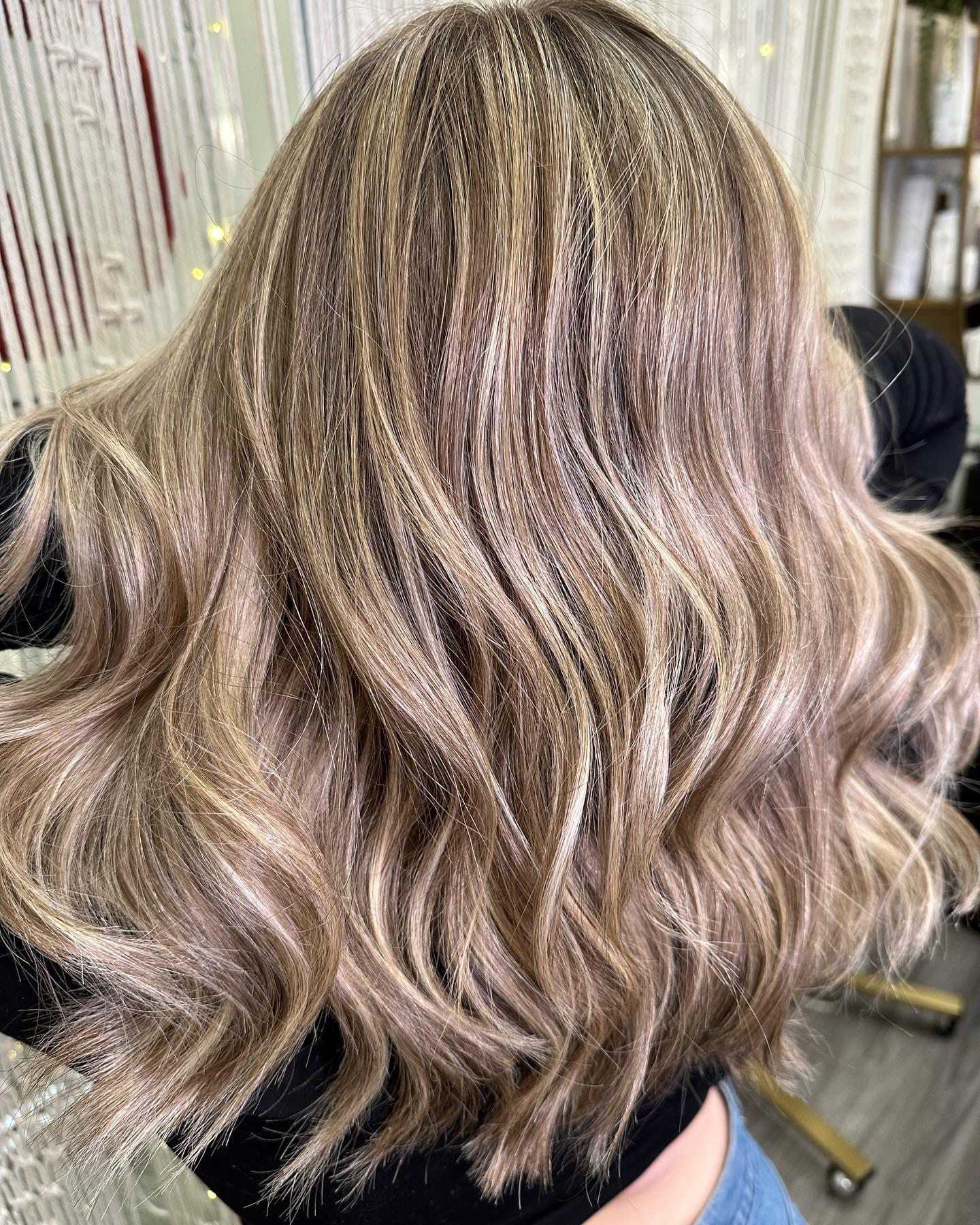 Woman with wavy chestnut brown hair with icy white blonde highlights.