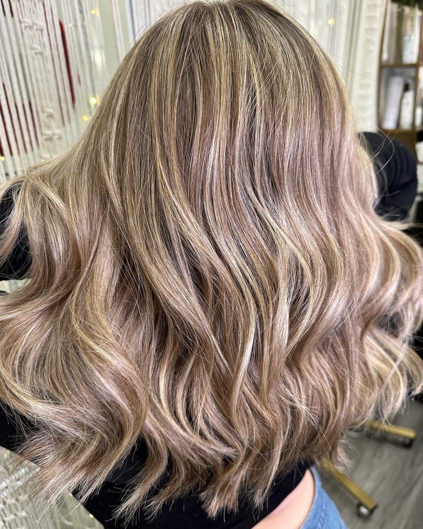 Woman with wavy chestnut brown hair with icy white blonde highlights.
