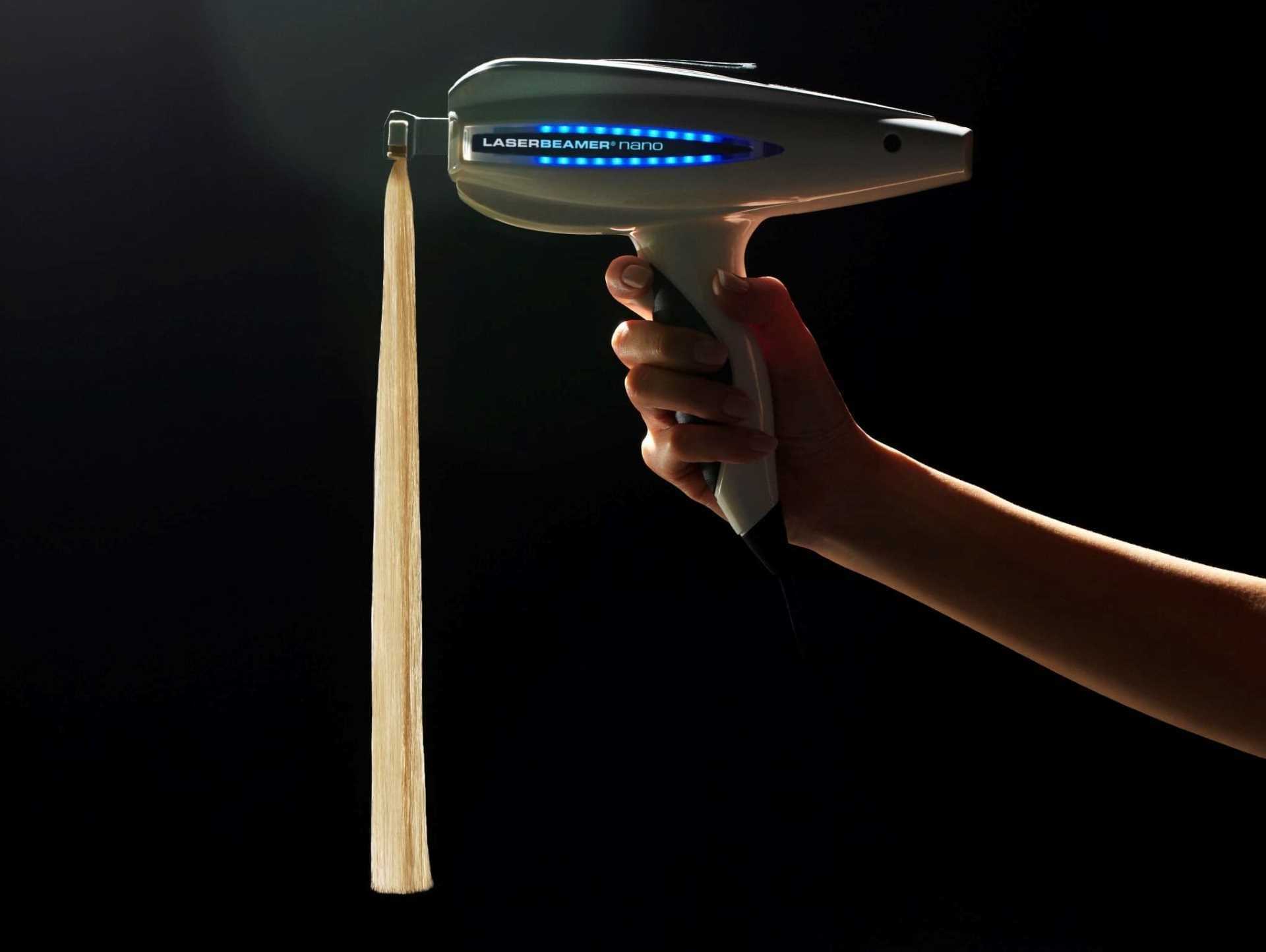 Hand holding a laser hair removal device with a glowing panel.